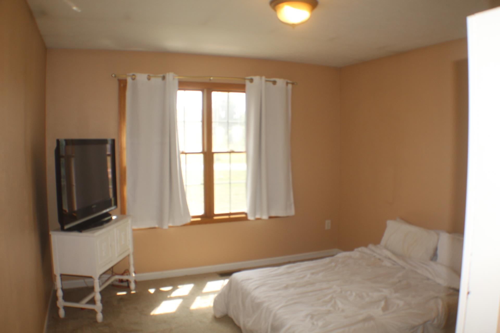 9190 North Barker Road Byron, IL 61010 - Photo 22 of 53 a bedroom with a bed window and flat screen tv