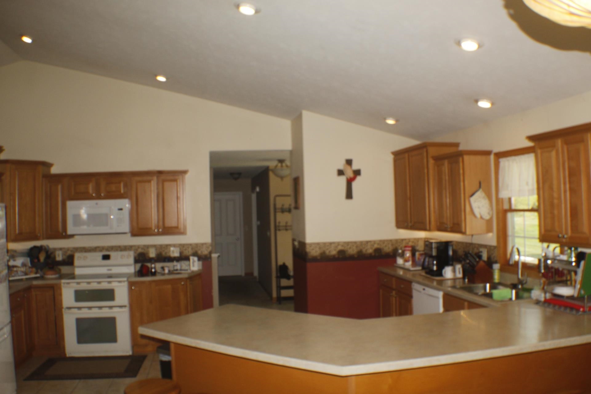 9190 North Barker Road Byron, IL 61010 - Photo 7 of 53 a large kitchen with stainless steel appliances a large counter top a stove a refrigerator a sink and a microwave