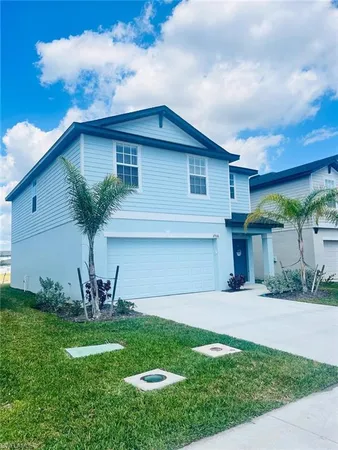 a front view of a house with a garden and yard