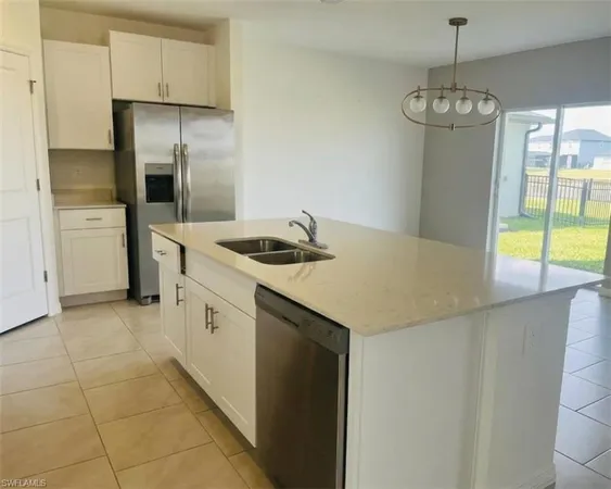 a kitchen with stainless steel appliances granite countertop a sink a refrigerator and a stove