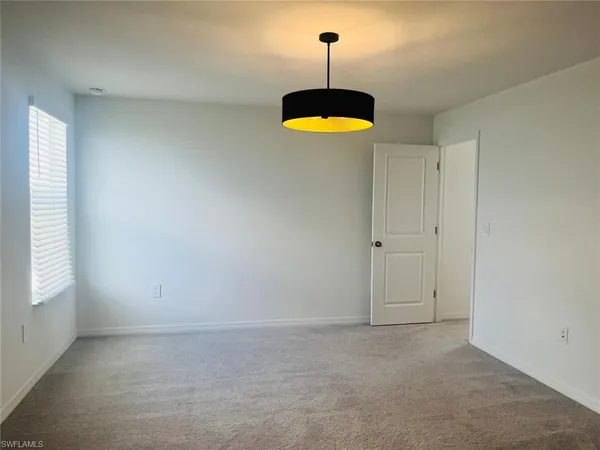 a view of a room with window and chandelier fan