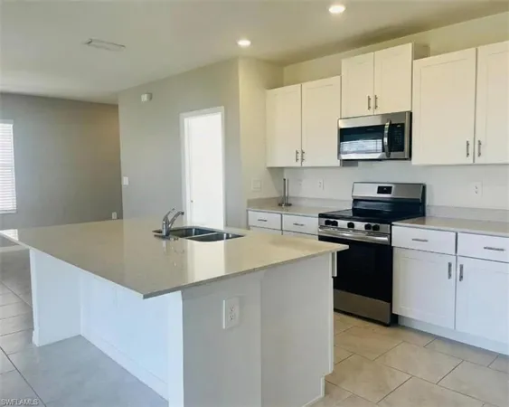 a kitchen with stainless steel appliances granite countertop a sink a stove and a refrigerator