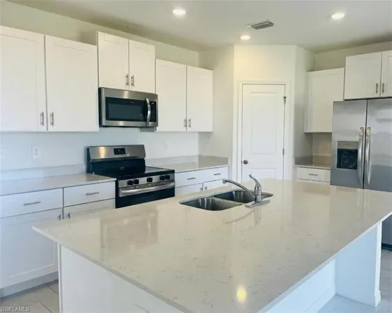 a kitchen with stainless steel appliances a stove a sink a microwave and cabinets