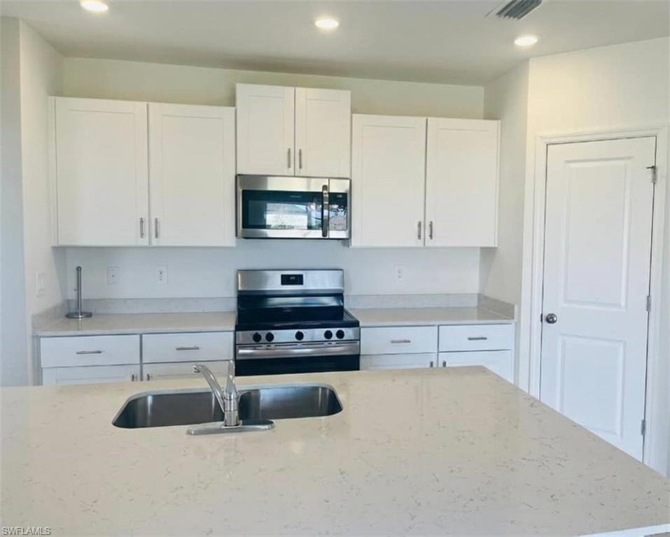 17536 Monte Isola Way North Fort Myers, FL 33917 - Photo 9 of 19 a kitchen with cabinets and a stove top oven