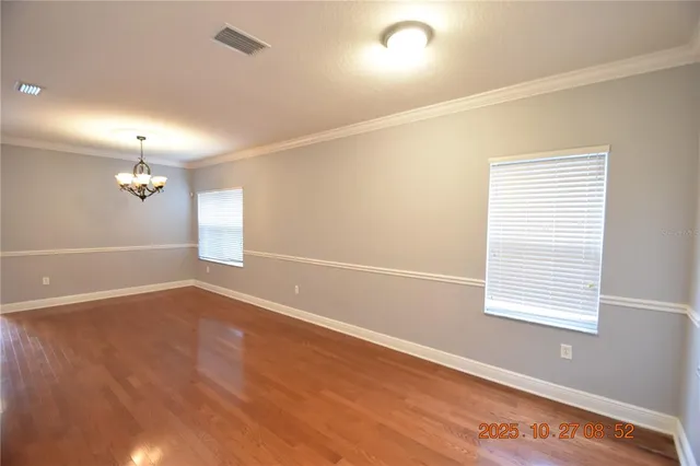 a view of a room with wooden floor cabinets and a chandelier