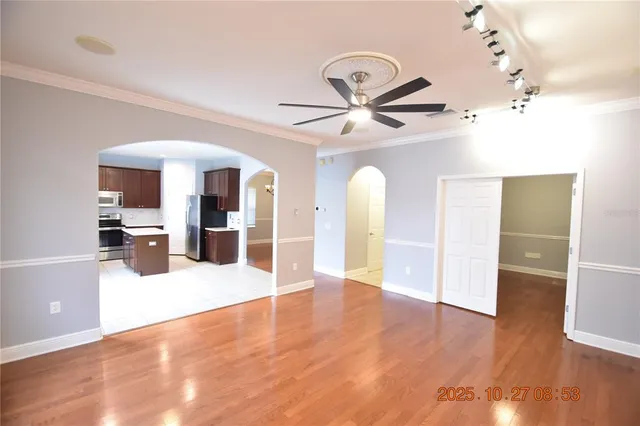 a kitchen with refrigerator and wooden floor