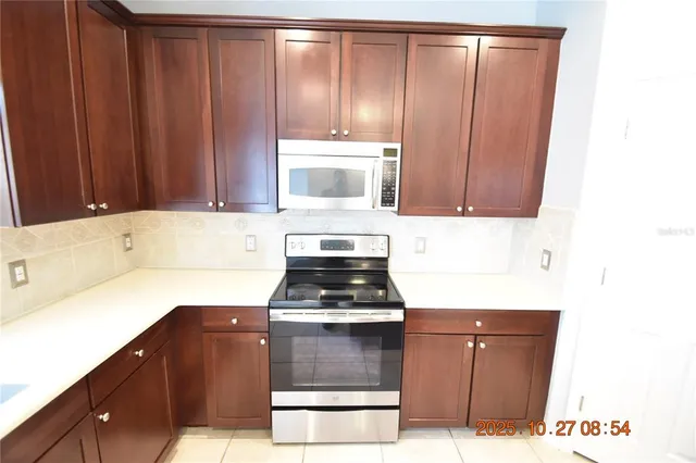 a kitchen with a sink a stove cabinets and a window