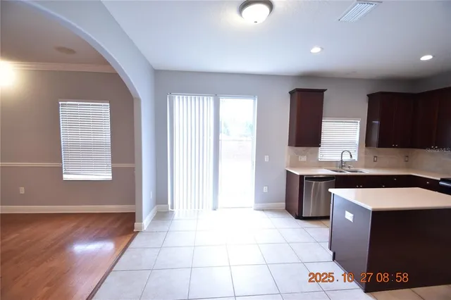 an empty room with wooden floor and fan