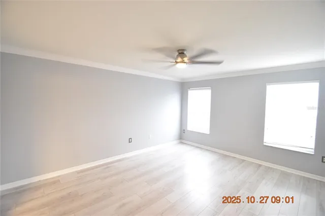 an empty room with windows and fan