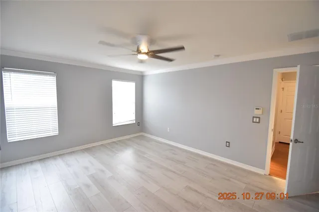 an empty room with windows and fan