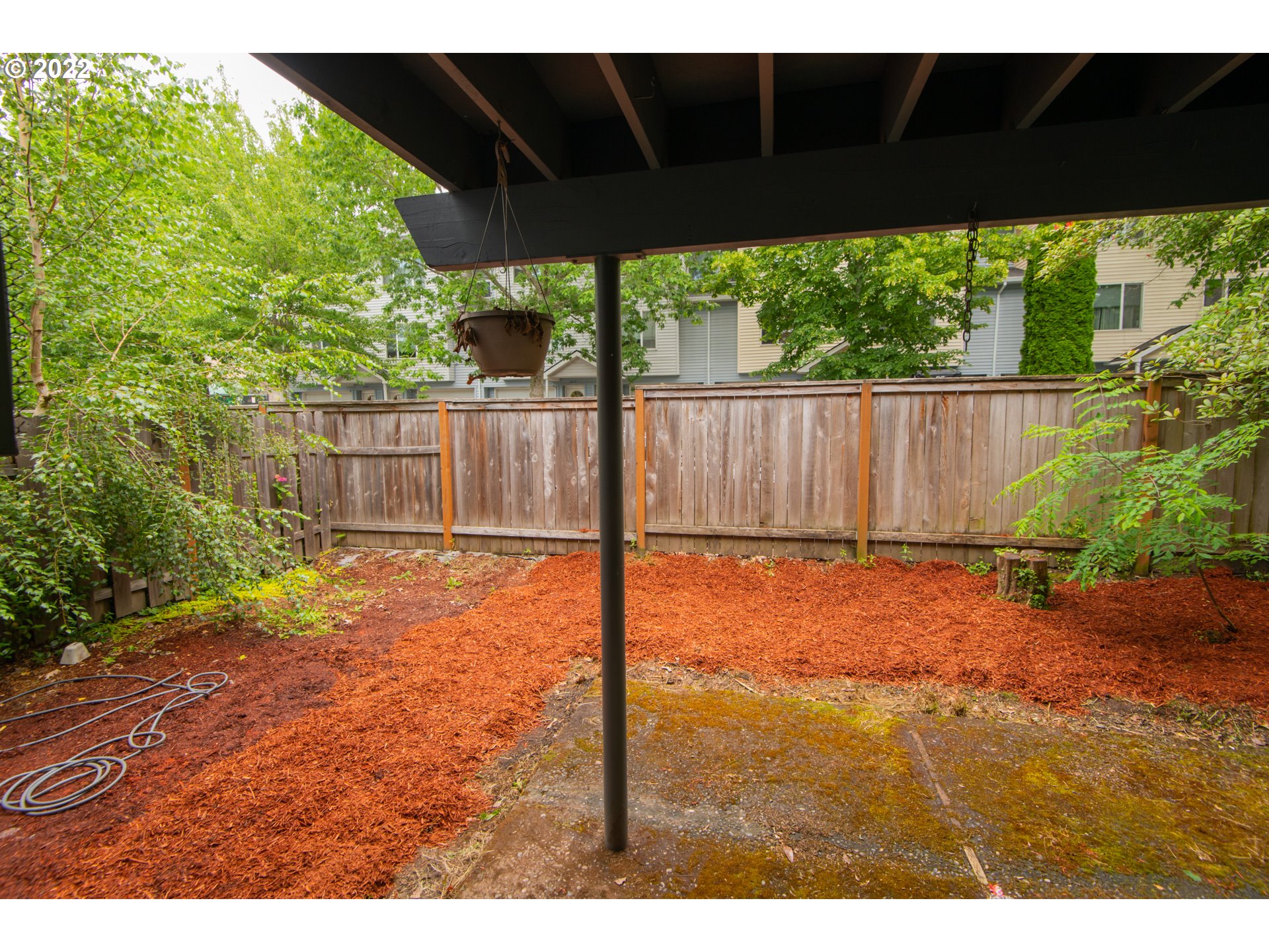 8960 Southwest Cashmur Lane Portland, OR 97225 - Photo 15 of 19 a view of a backyard with plants and wooden fence