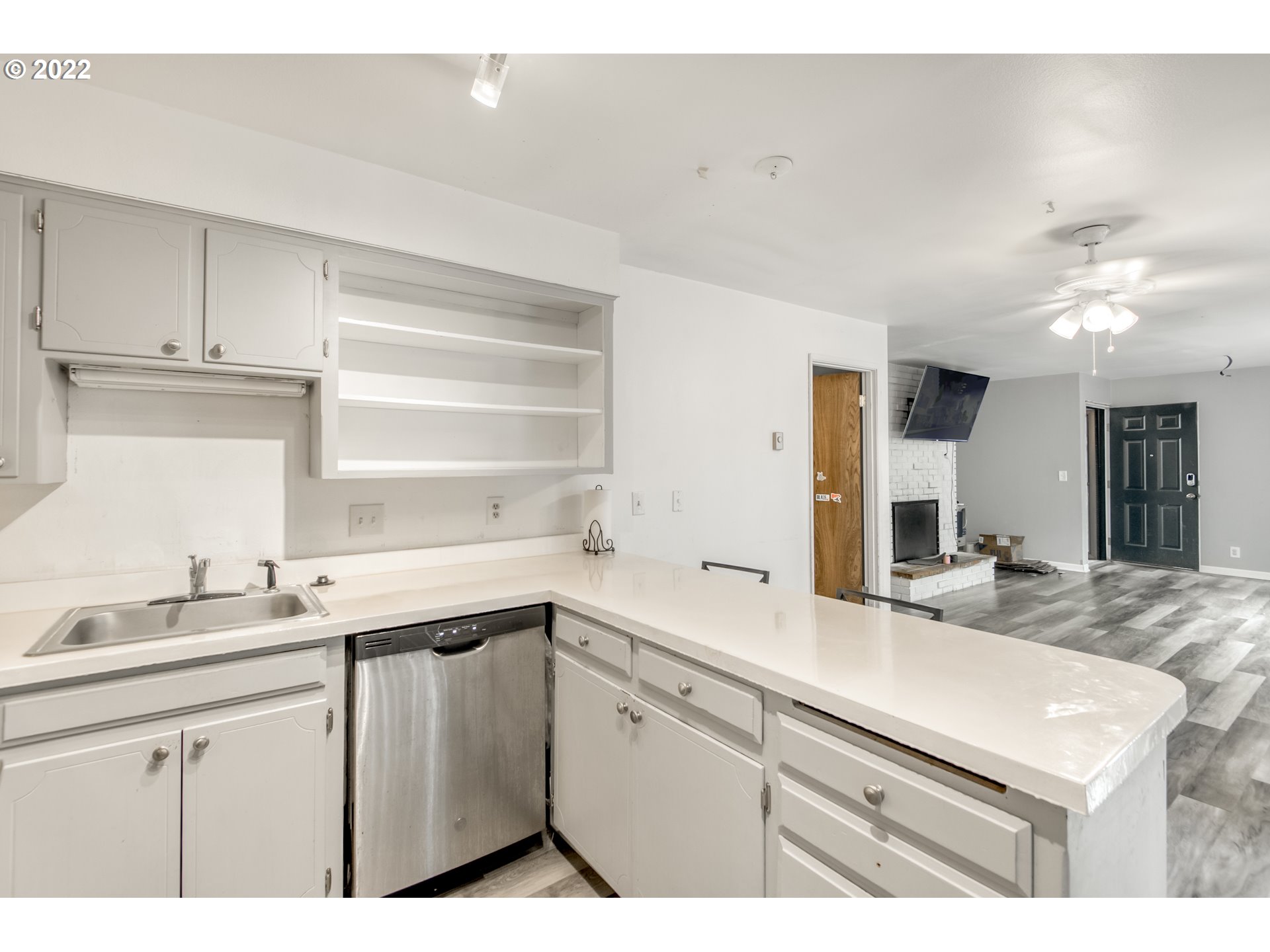8960 Southwest Cashmur Lane Portland, OR 97225 - Photo 8 of 19 a kitchen with a sink dishwasher a stove and white cabinets with wooden floor