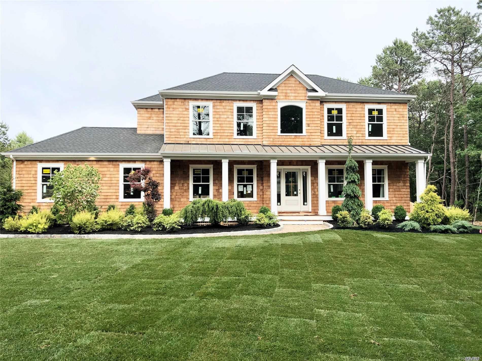 front view of a brick house with a yard