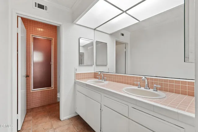 a bathroom with a sink double vanity and a mirror