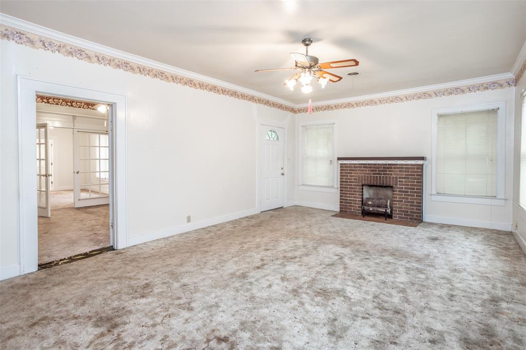 206 Ritchey Street Gainesville, TX 76240 - Photo 9 of 36 an empty room with a ceiling fan and a window