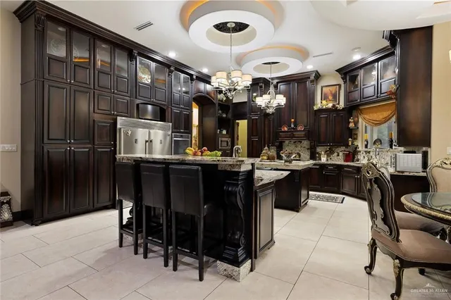a kitchen with a dining table chairs cabinets and stainless steel appliances