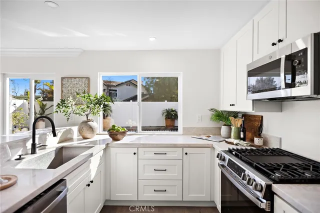 a kitchen with white cabinets and stainless steel appliances