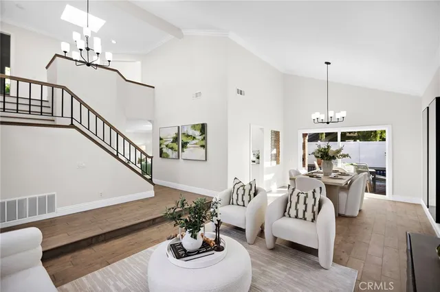 a living room with furniture chandelier and a table