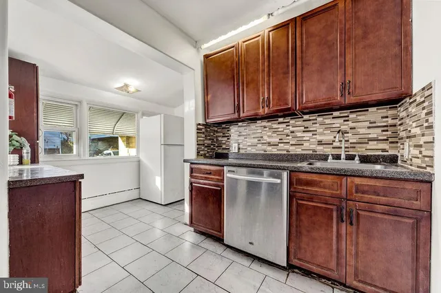 a kitchen with stainless steel appliances granite countertop wooden cabinets a sink and dishwasher