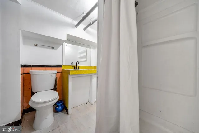a white toilet sitting next to a shower