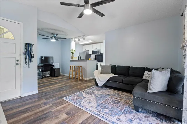a living room with furniture and a wooden floor
