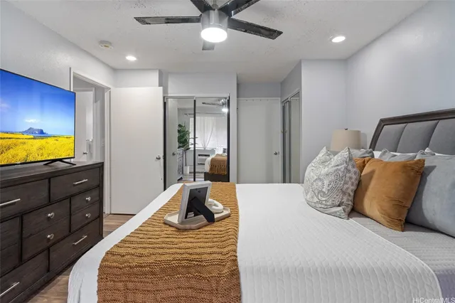 a bedroom with a bed and ceiling fan