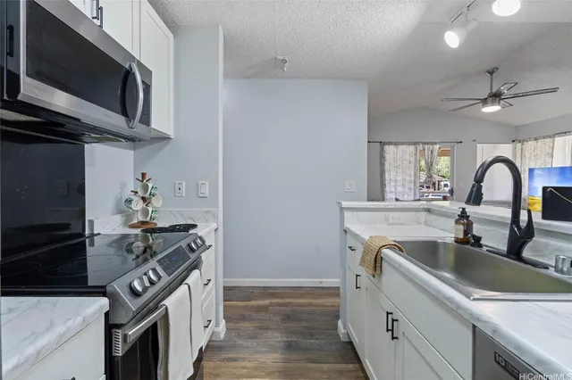 a kitchen with stainless steel appliances granite countertop a sink stove and microwave