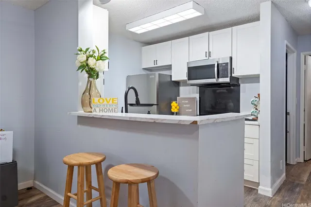 a kitchen with stainless steel appliances a white refrigerator a microwave and cabinets
