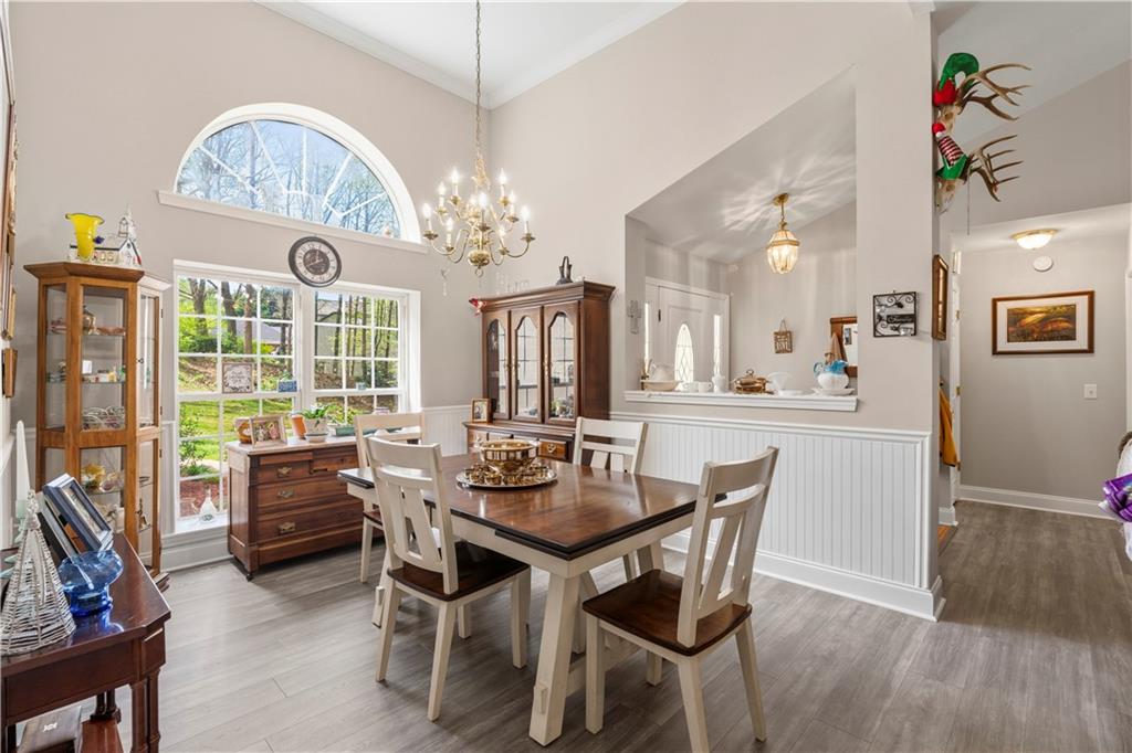 3724 Lexington Court Gainesville, GA 30504 - Photo 9 of 56 a dining room with wooden floor a chandelier a wooden table and chairs