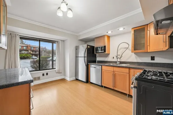 a kitchen with stainless steel appliances granite countertop a stove a sink and a refrigerator