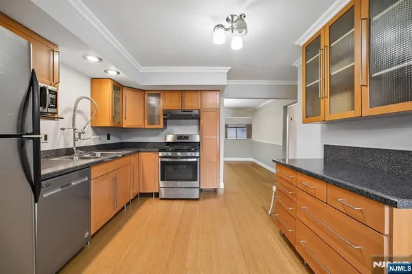a kitchen with stainless steel appliances granite countertop a stove a sink and a refrigerator