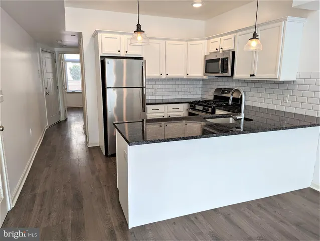 a kitchen with stainless steel appliances a refrigerator sink and microwave