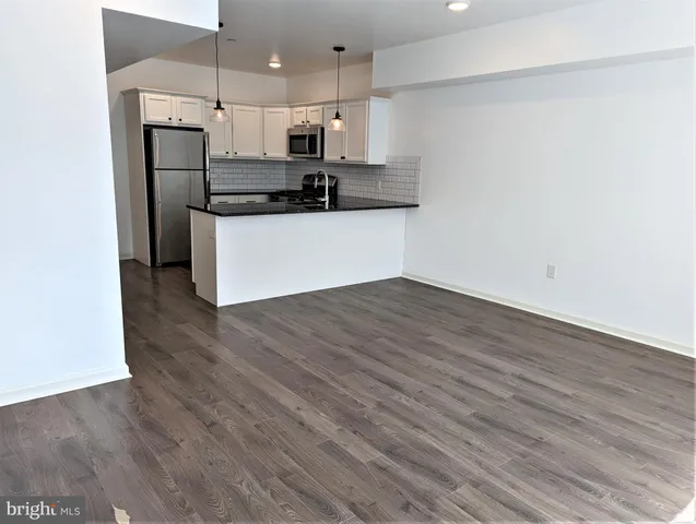 a kitchen with stainless steel appliances a refrigerator and a stove top oven