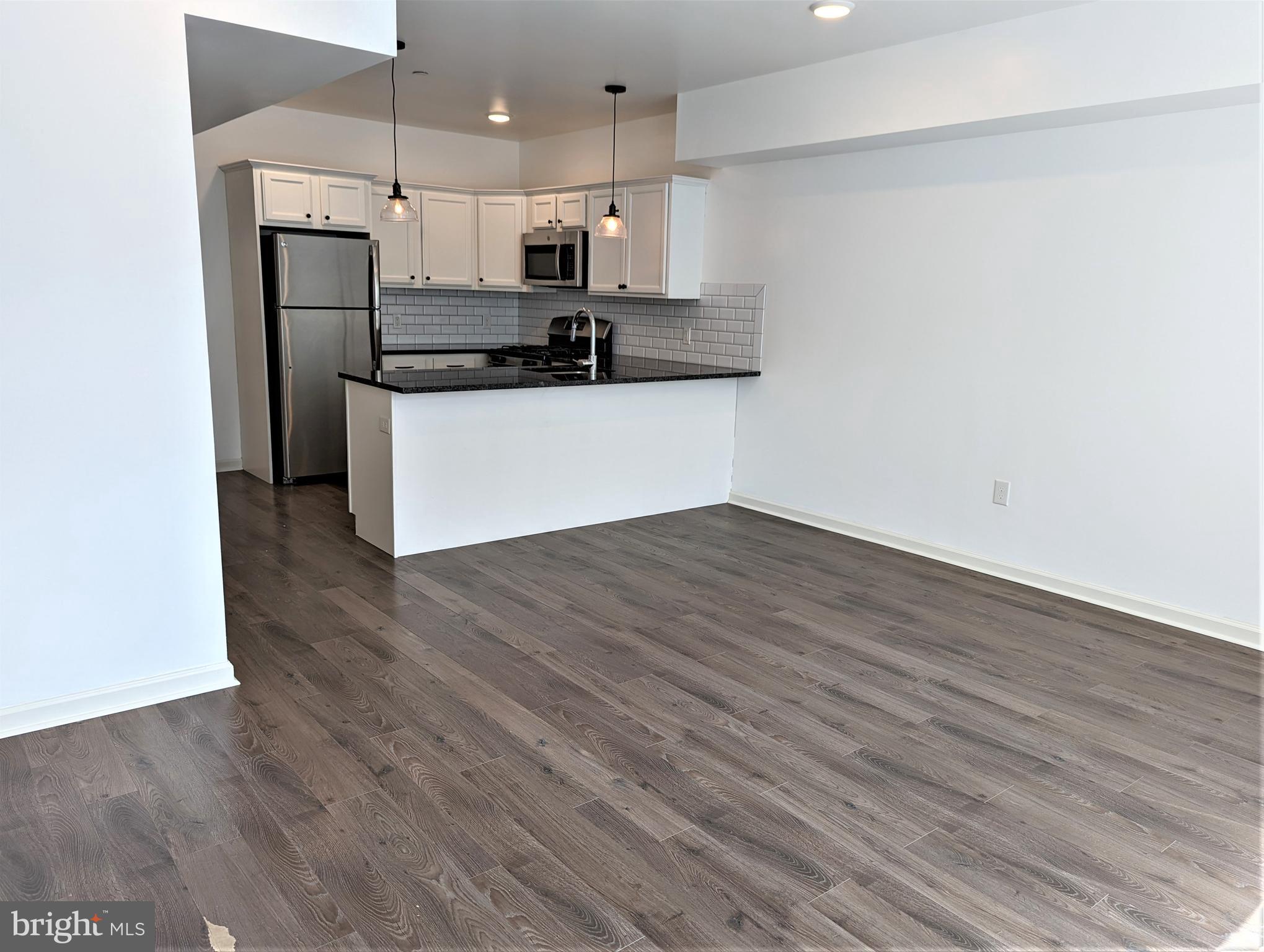 6615 Ridge Avenue, Unit 201 Philadelphia, PA 19128 - Photo 5 of 10 a kitchen with stainless steel appliances a refrigerator and a stove top oven