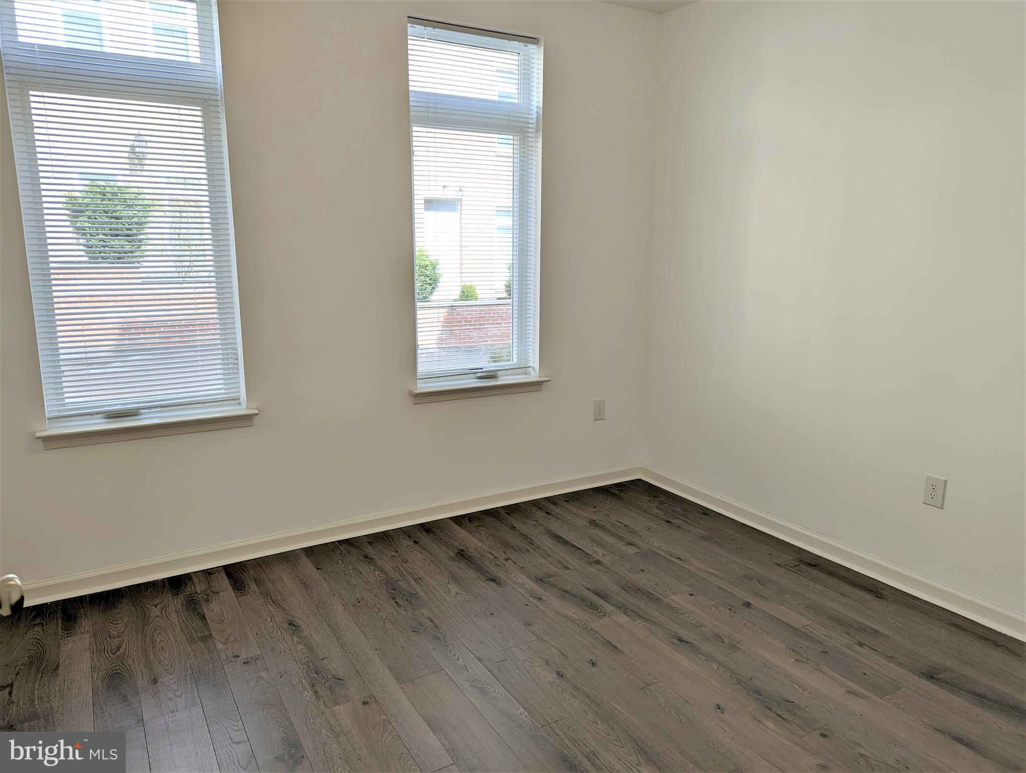 6615 Ridge Avenue, Unit 201 Philadelphia, PA 19128 - Photo 6 of 10 an empty room with wooden floor and windows