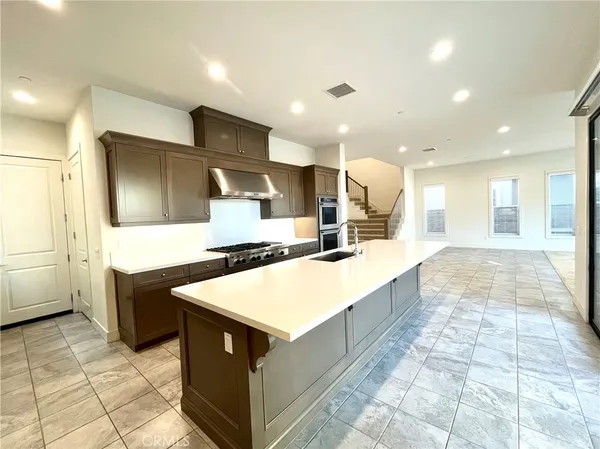 a large kitchen with a large counter top and stainless steel appliances