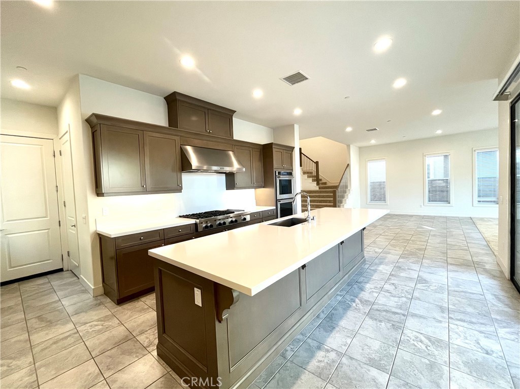 12040 Estrella Place Porter Ranch, CA 91326 - Photo 7 of 32 a large kitchen with a large counter top and stainless steel appliances