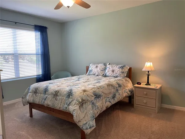 a bedroom with a bed and a lamp next to a window