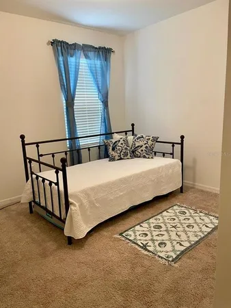 a bed sitting in a bedroom next to a window