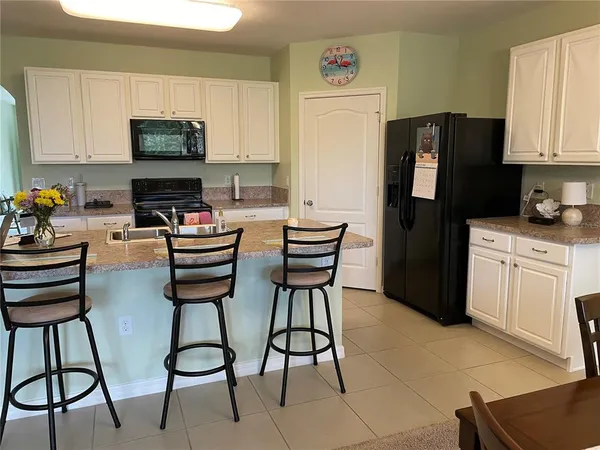 a kitchen with stainless steel appliances kitchen island granite countertop a refrigerator and a stove top oven