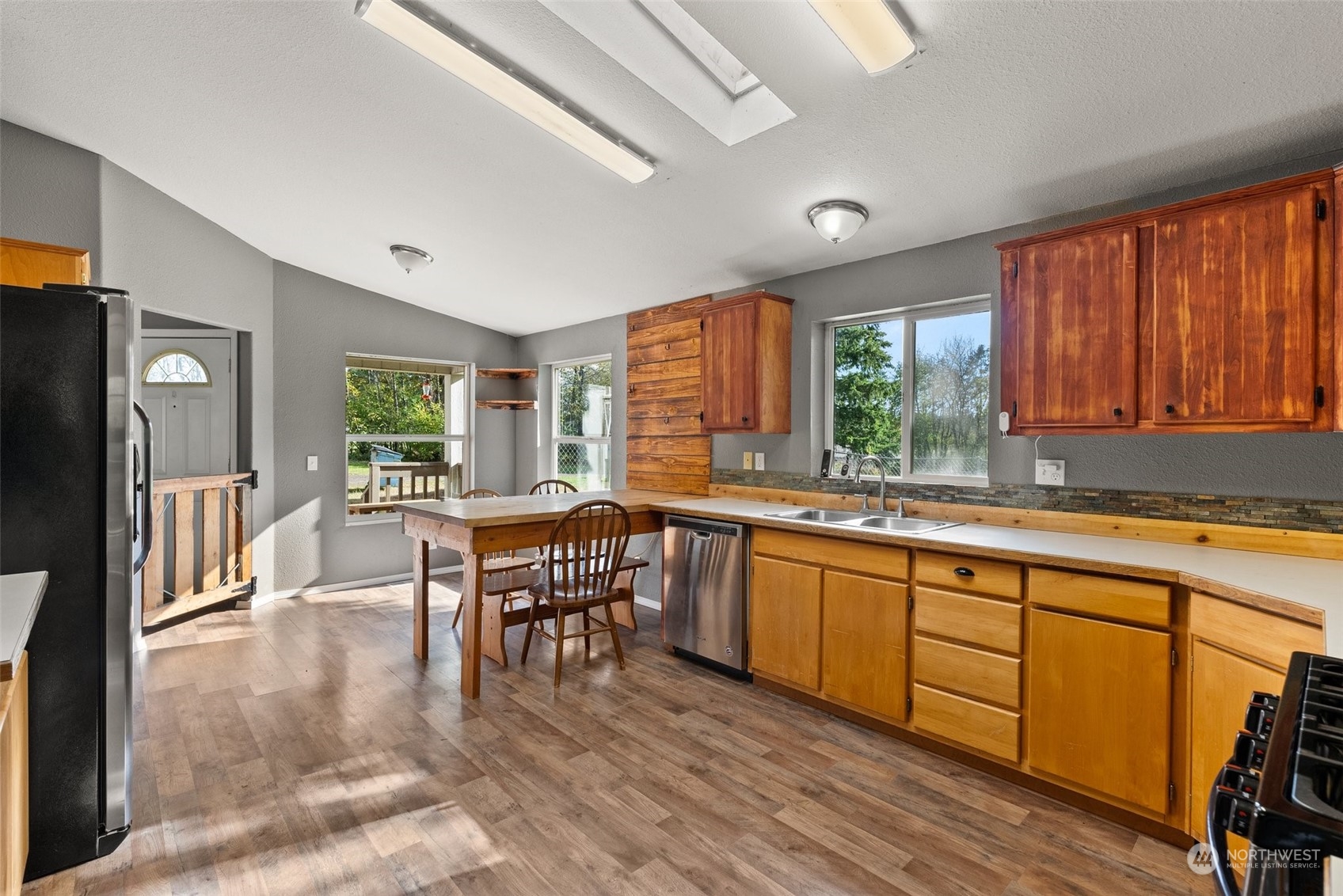 138 Pleasant Valley Road Winlock, WA 98596 - Photo 8 of 34 a kitchen with stainless steel appliances granite countertop a stove a sink dishwasher a dining table and chairs with wooden floor