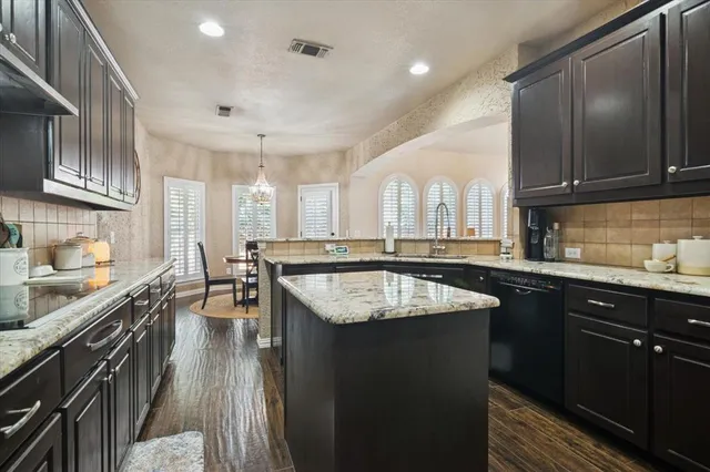 a kitchen with stainless steel appliances granite countertop a sink stove and cabinets