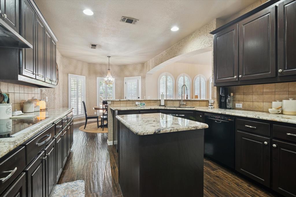 1602 Crown Point Road McKinney, TX 75072 - Photo 13 of 40 a kitchen with stainless steel appliances granite countertop a sink stove and cabinets