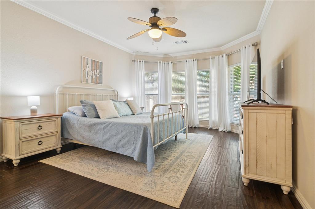 1602 Crown Point Road McKinney, TX 75072 - Photo 18 of 40 a spacious bedroom with a bed and a chandelier