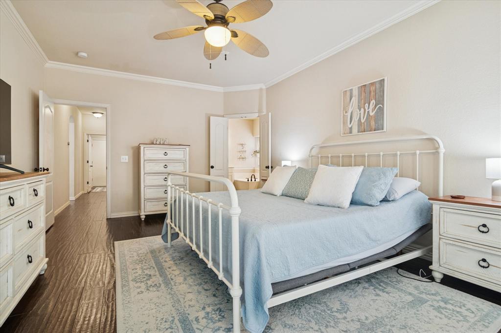 1602 Crown Point Road McKinney, TX 75072 - Photo 20 of 40 a bedroom with a bed and a chandelier