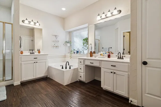 a bathroom with a double vanity sink mirror and bathtub