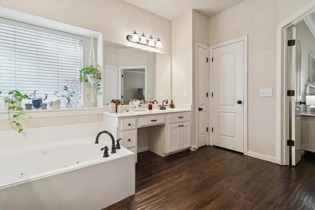 a bathroom with a tub a sink and a mirror