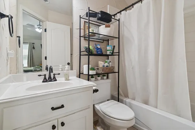 a bathroom with a sink a toilet a mirror and shower curtain