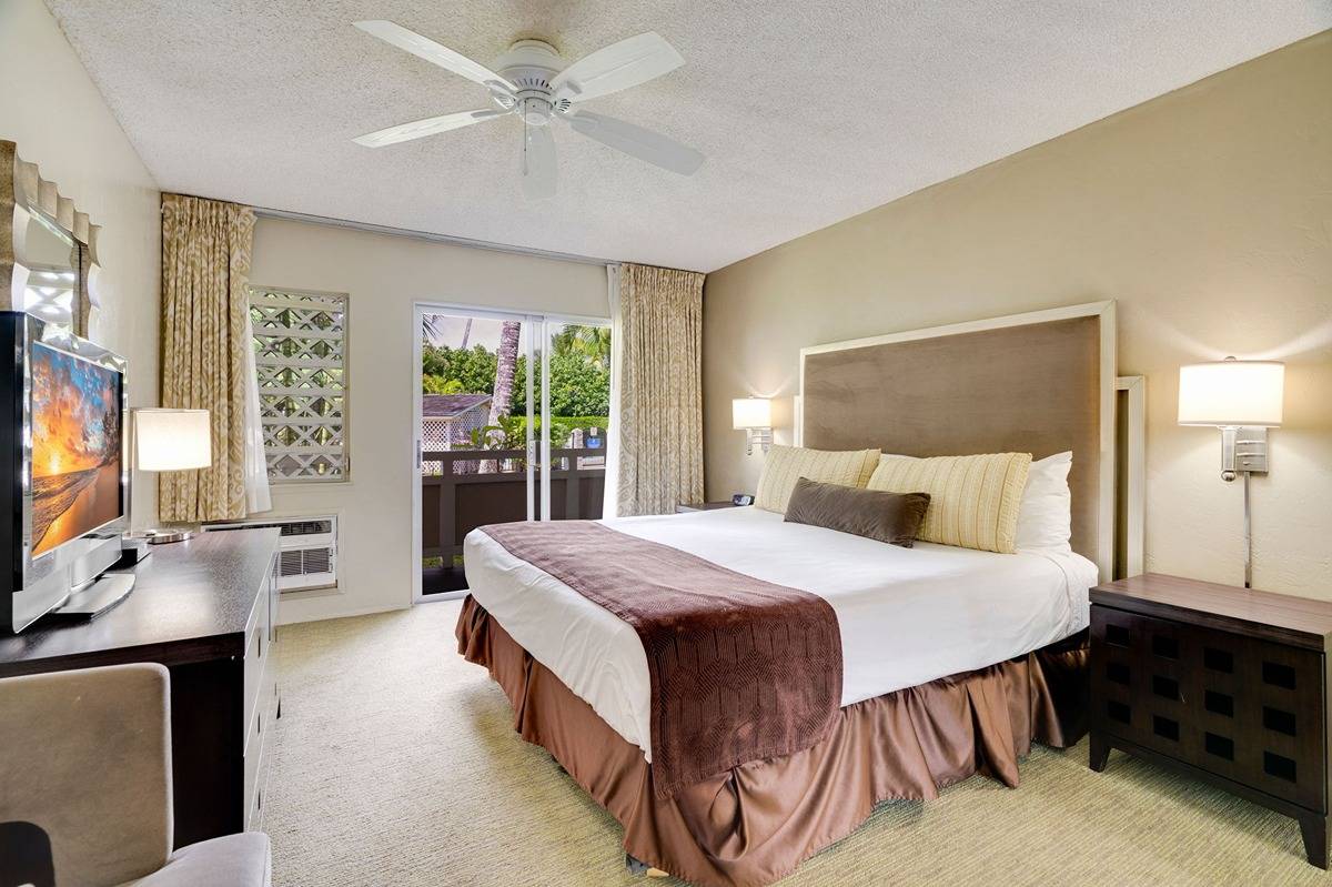 525 Aleka Loop, Unit C5 Kapaa, HI 96746 - Photo 12 of 24 a bedroom with a large bed and a flat tv screen on dresser
