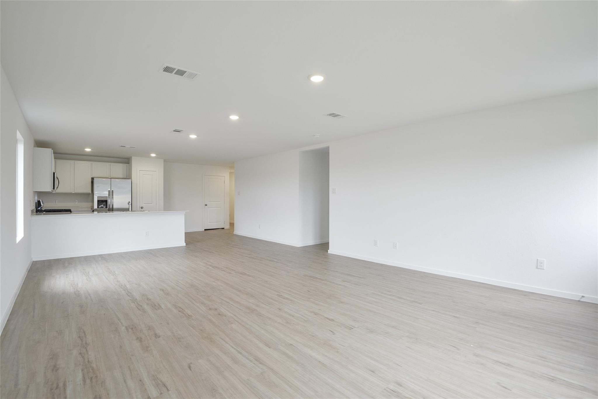 13746 Kit Run Splendora, TX 77372 - Photo 11 of 22 a view of a big room with wooden floor and a kitchen